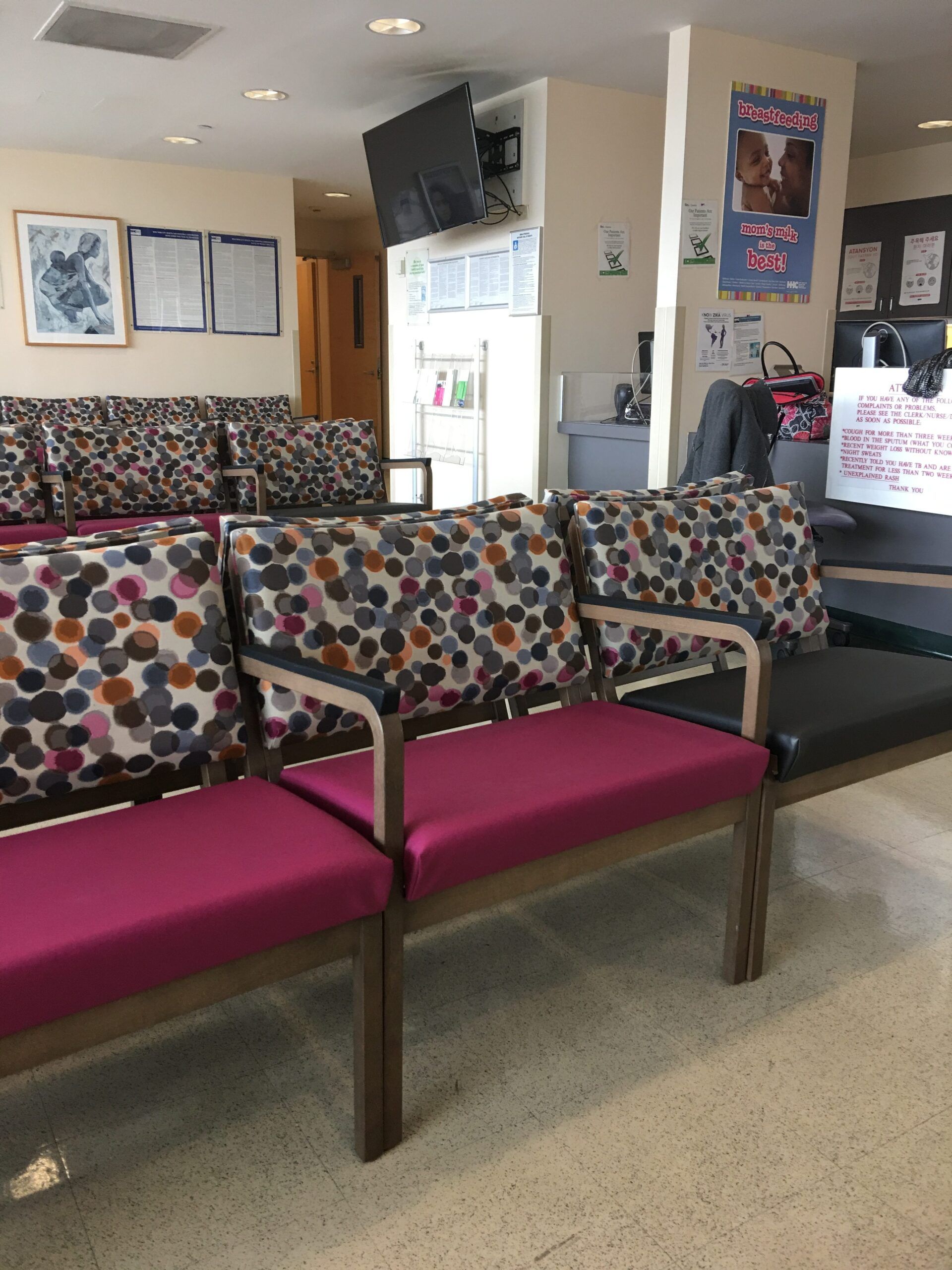 A waiting room with pink chairs and a couch