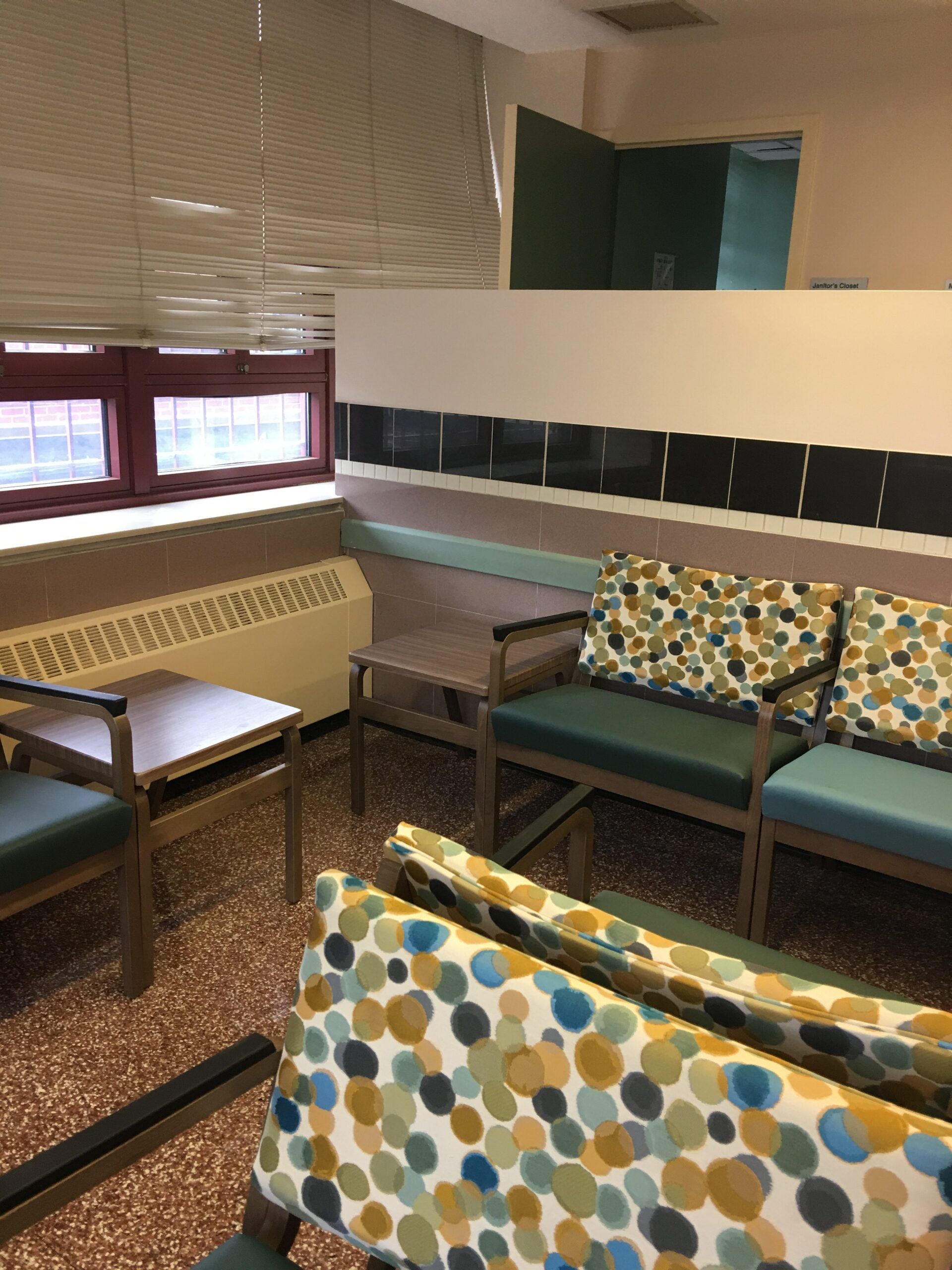 A waiting room with chairs and a couch with polka dots on it