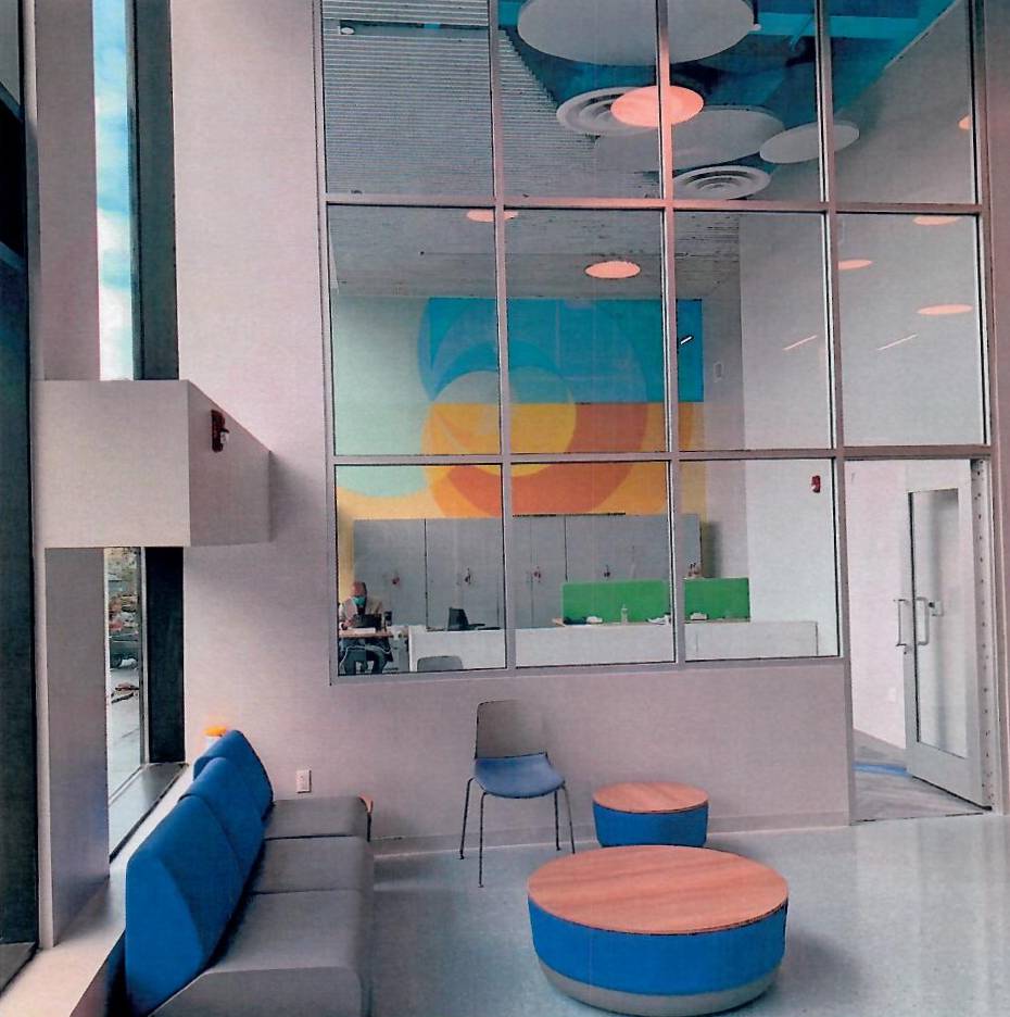 A room with a lot of windows and blue furniture