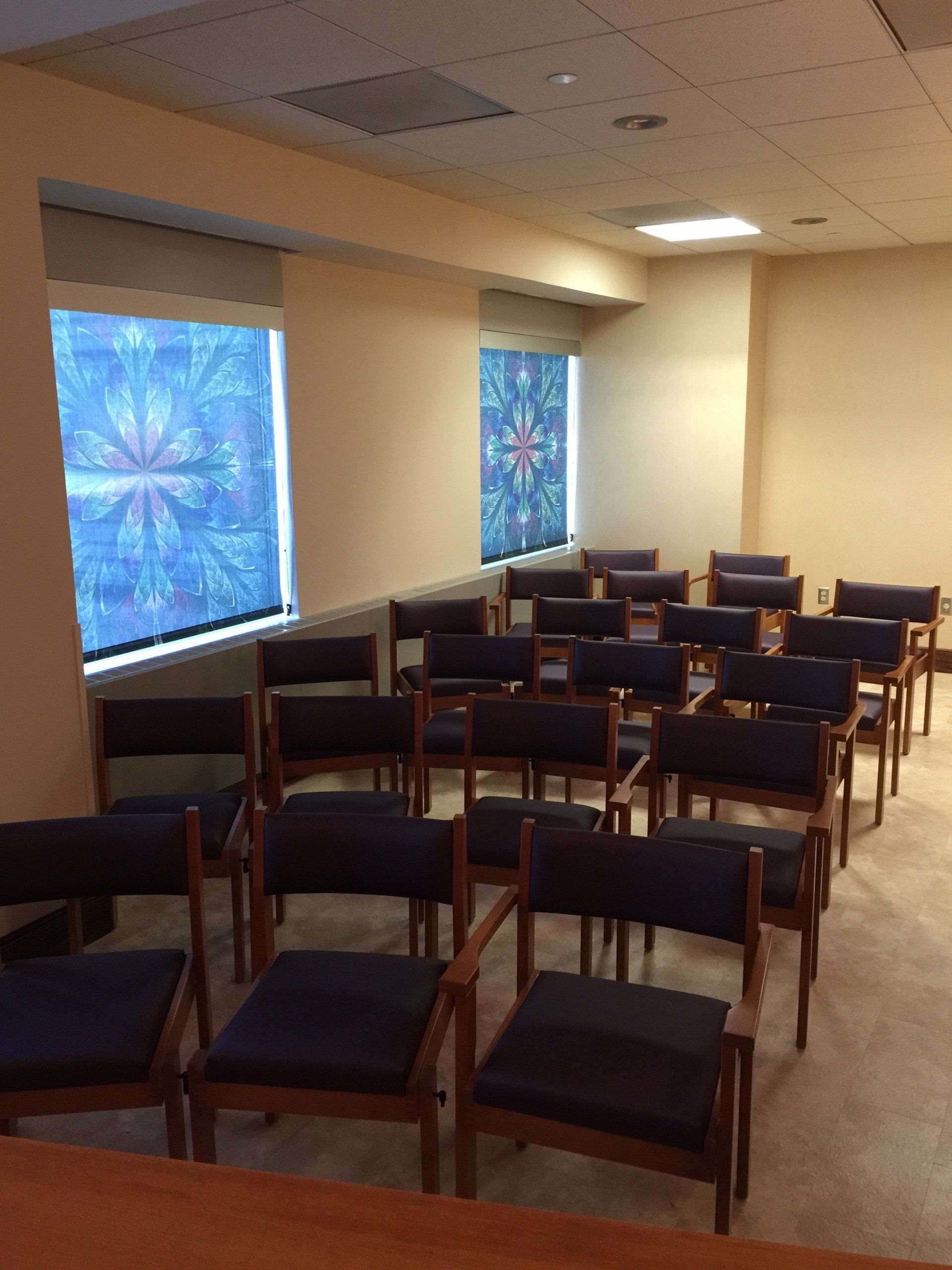 Rows of chairs in a room with a stained glass window