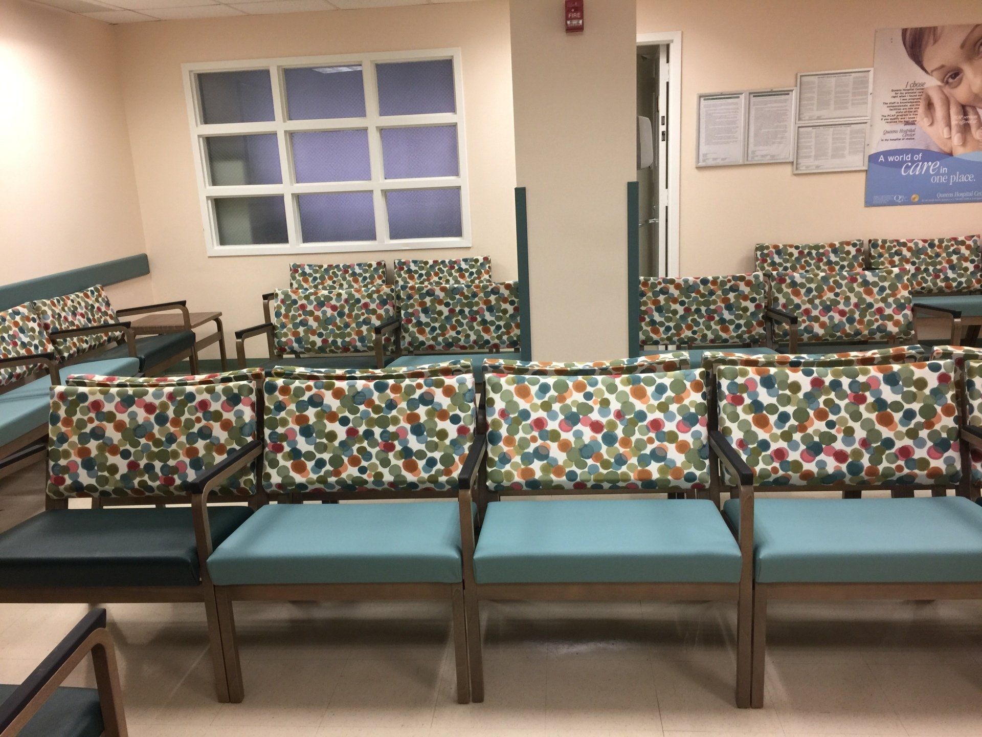A waiting room with colorful chairs and a window