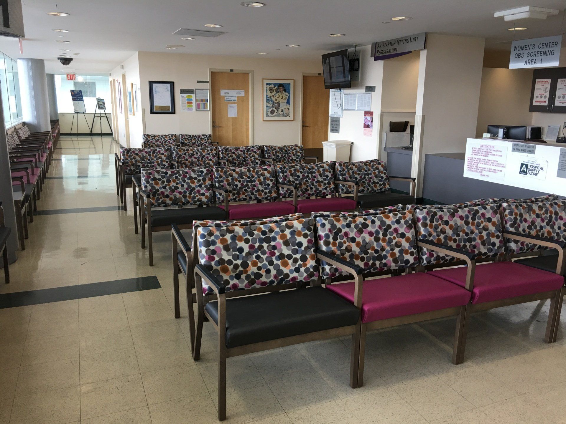 A hospital waiting room with colorful chairs and a counter
