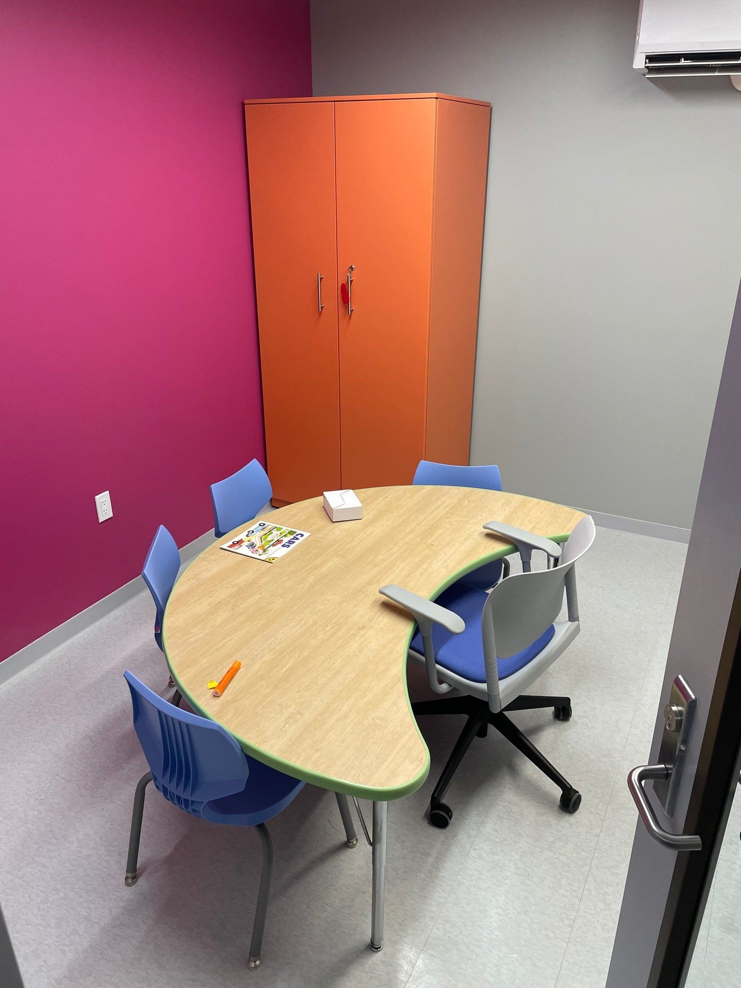 A room with a round table and chairs in it