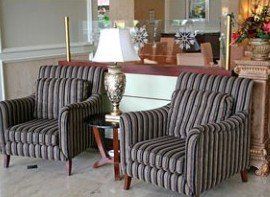 Two striped chairs are sitting next to each other in a lobby.