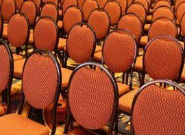 Rows of orange chairs are lined up in a room