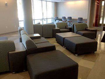 A living room with a lot of chairs and ottomans