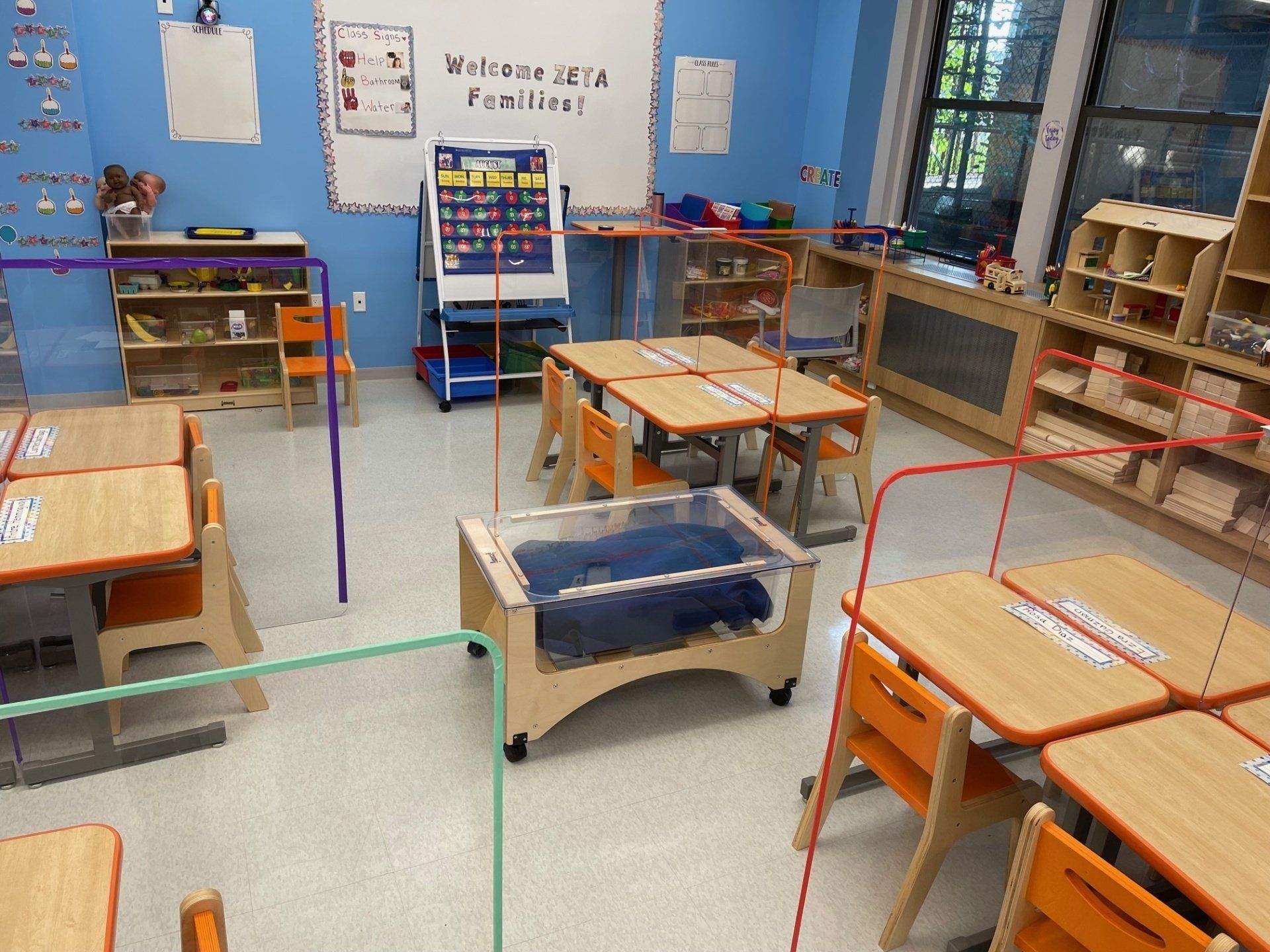 A classroom with tables and chairs and a welcome sign