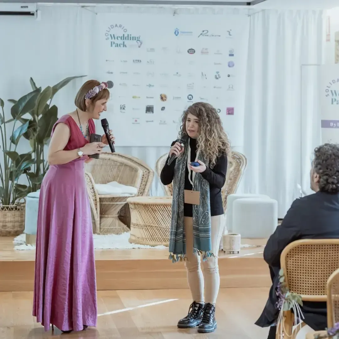 Una mujer con un vestido rosa canta frente a un micrófono