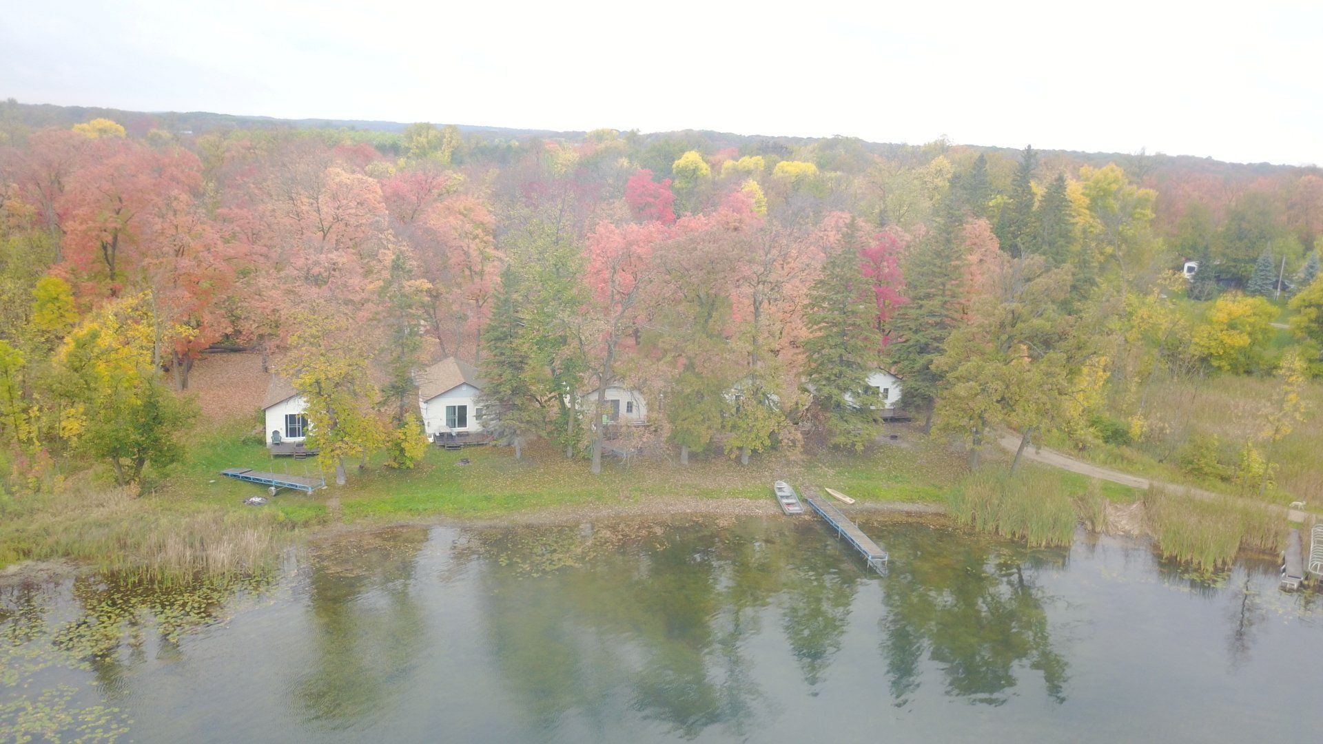 An aerial view of a lake surrounded by trees and houses.