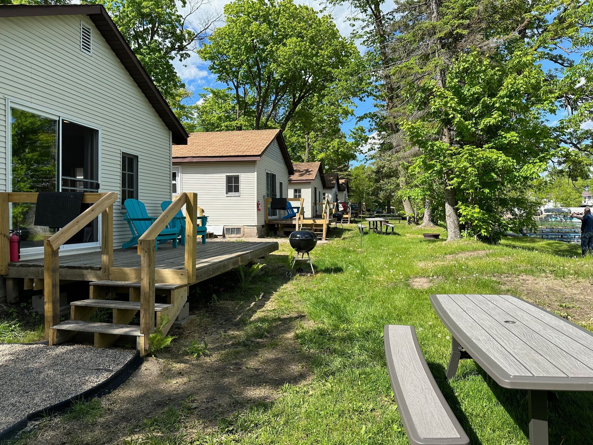A white house with a picnic table in front of it.