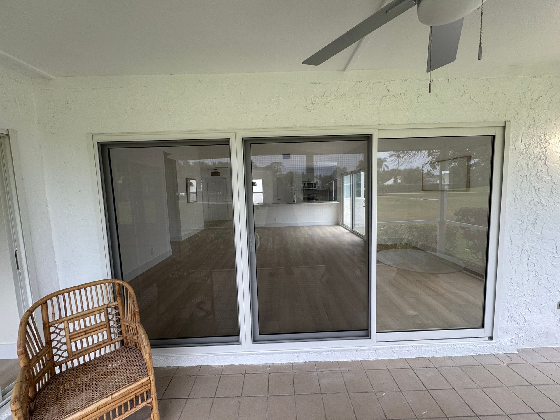 Sliding glass doors  on a tiled patio. Interior features hardwood floors and white walls. Palm Beach County 