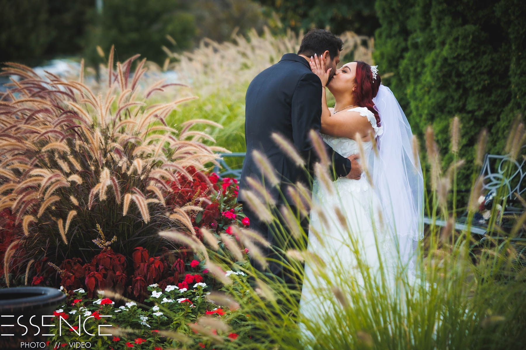 Bride and Groom kiss in landscaping