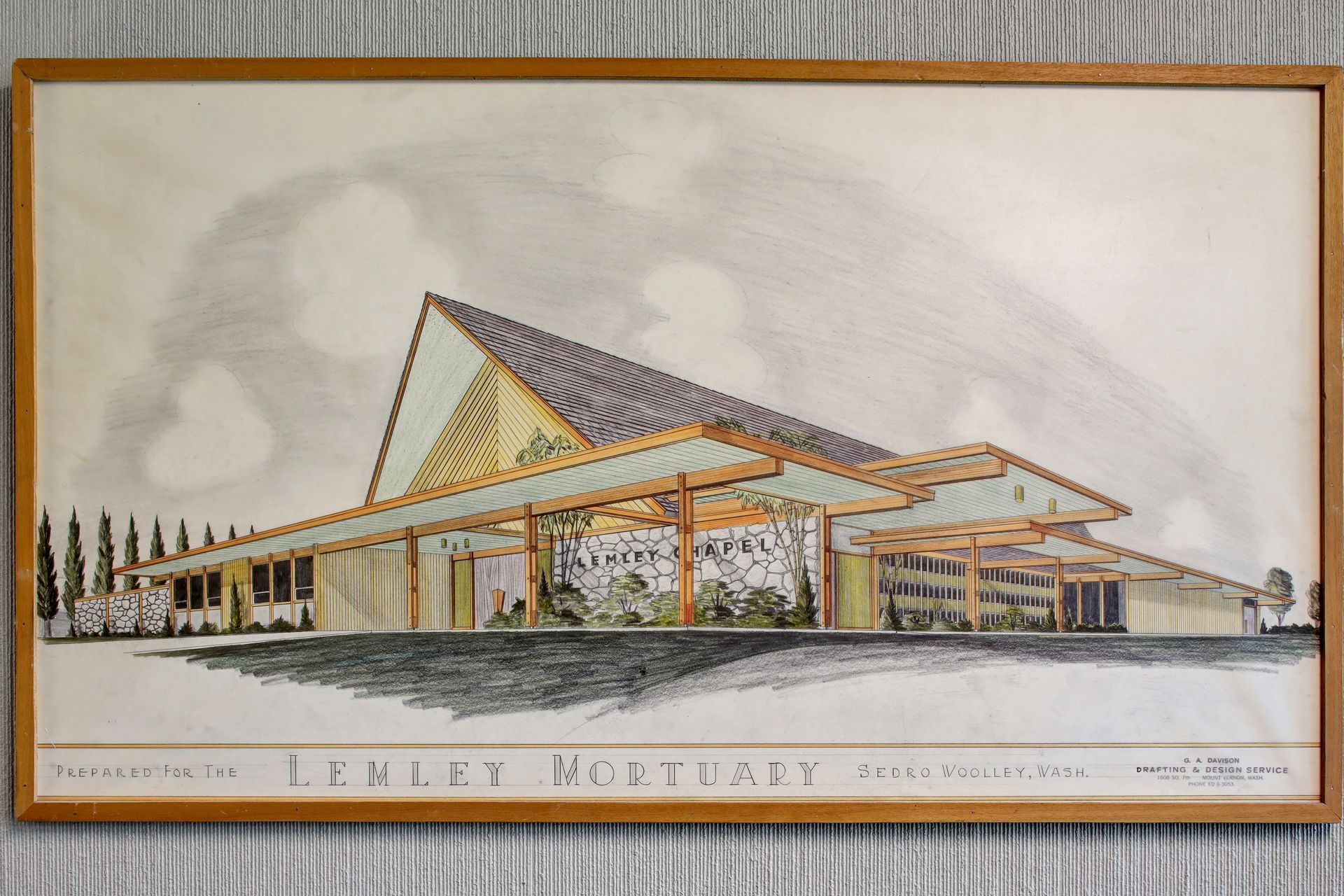 Architectural rendering of a modern building with a peaked roof and glass facade, labeled 