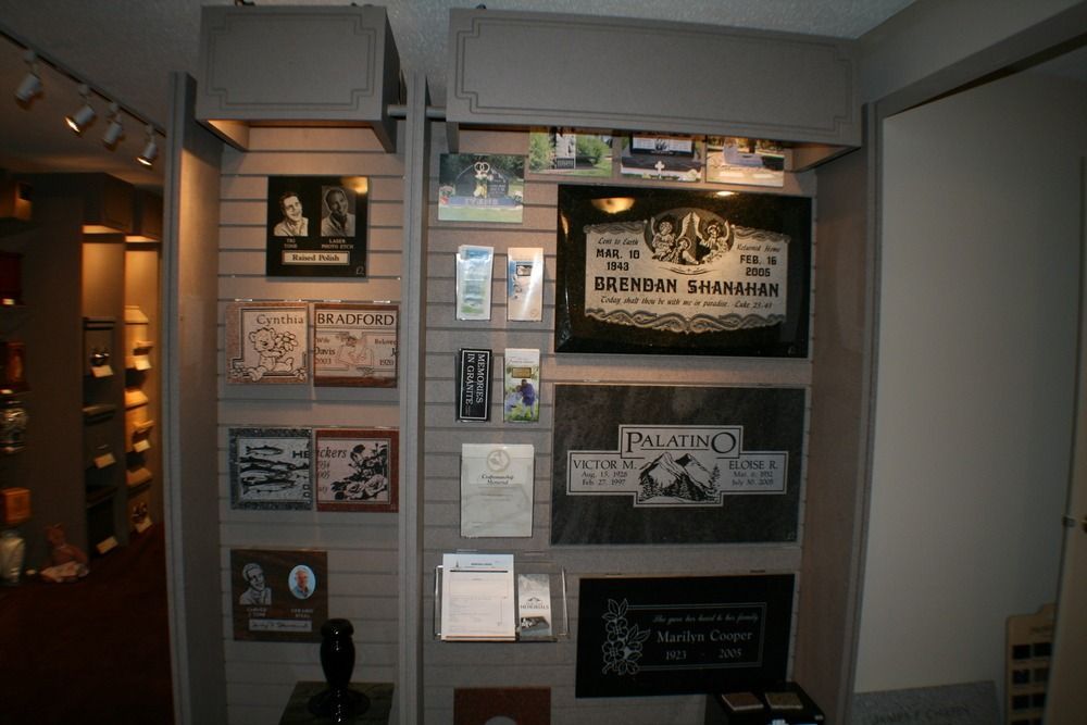 Museum display wall with framed historical posters, photos, and documents in a dim hallway
