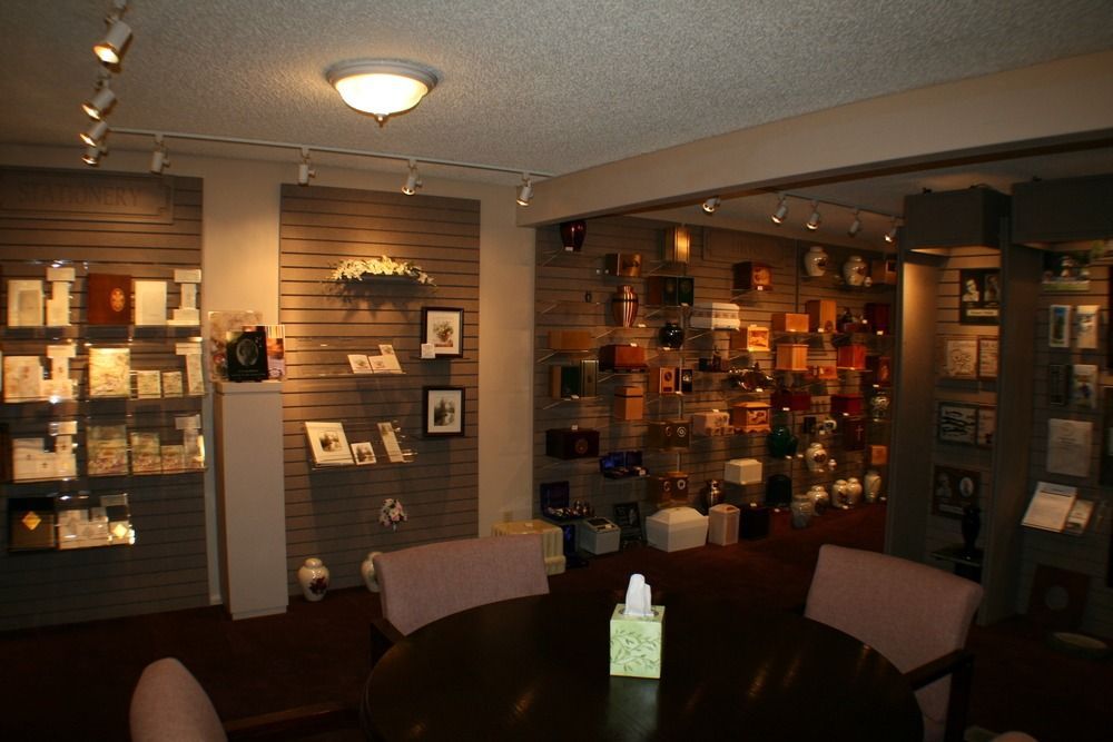 Warmly lit store interior with shelves, display cases, and a round table in the foreground.