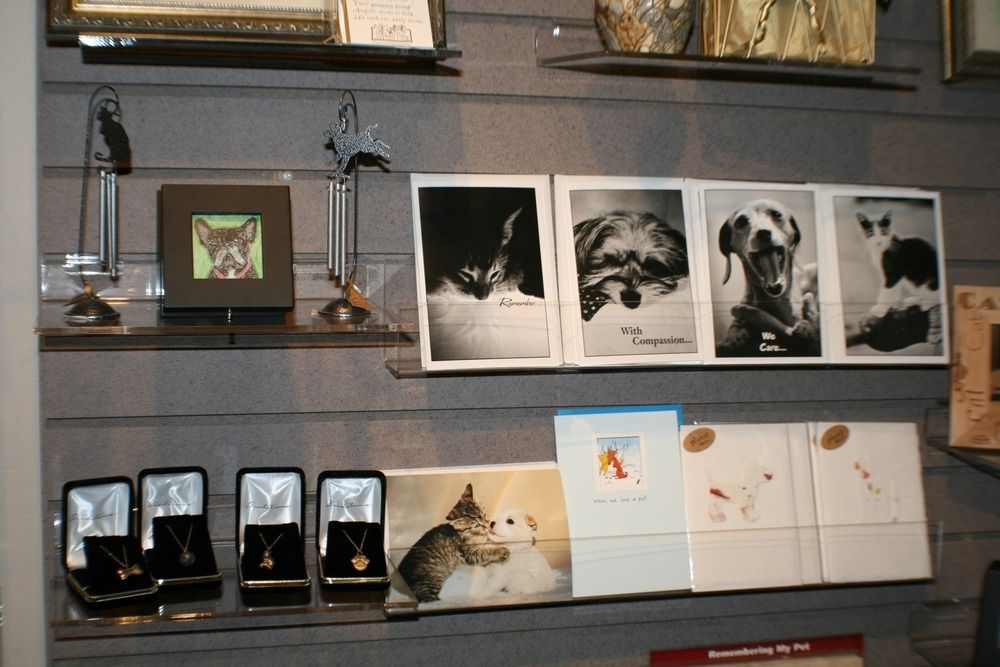 Pet display shelf with framed photos, small keepsakes, and cat-themed plaques