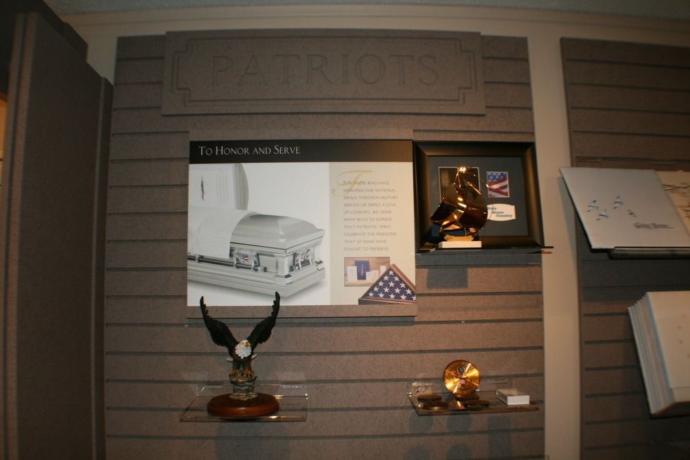Museum display wall with plaques, photos, a mounted eagle sculpture, and a small model scene