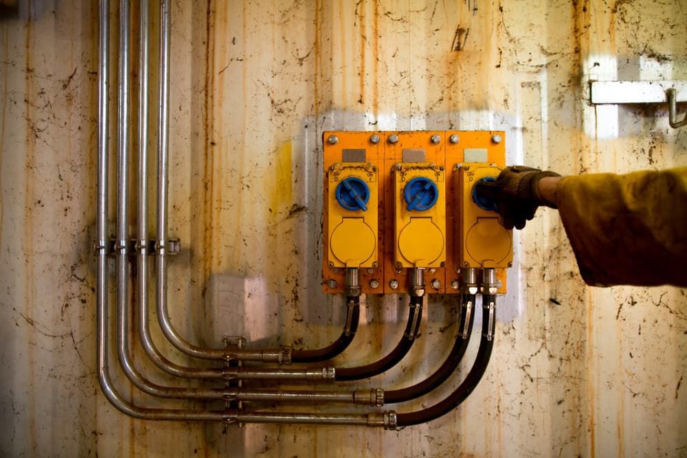 A Person Is Turning On A Switch On A Wall — Allpower Electrical Wholesalers Pty Ltd In Bungalow, QLD