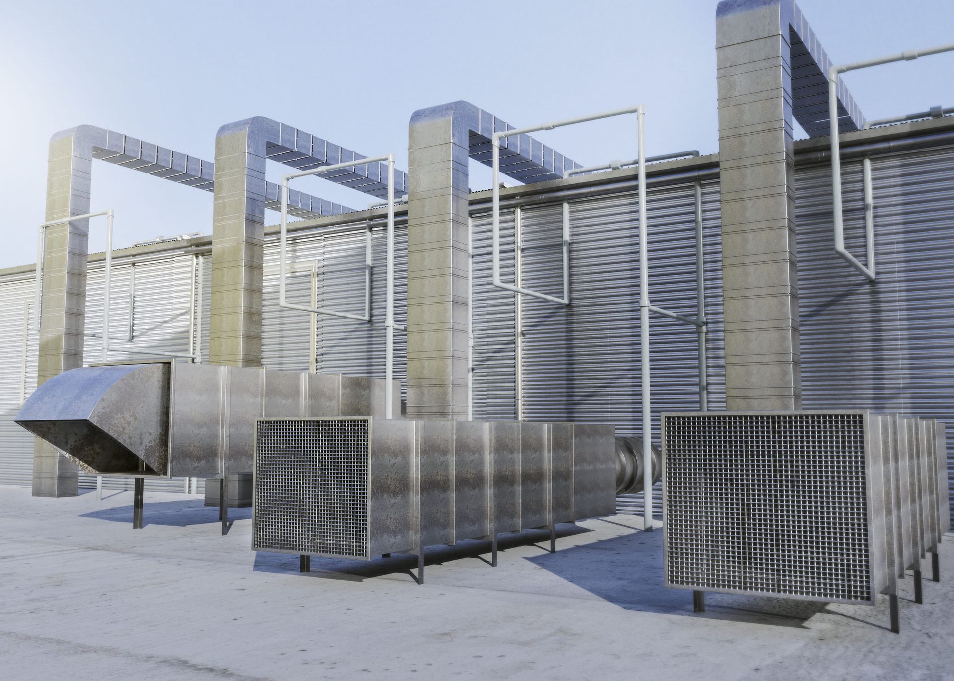Industrial rooftop cooling units and metal ductwork under a blue sky