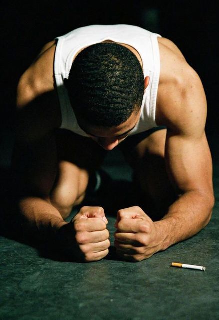 Columbus Athlete crouched with cigarette on the ground - trying to quit smoking