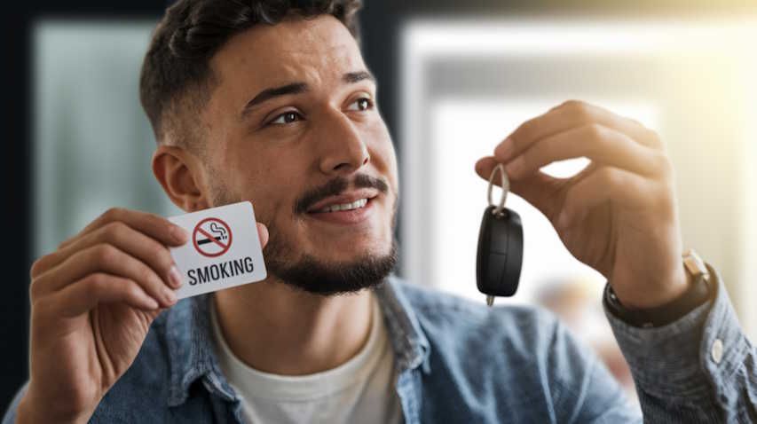 man who quit smoking thanks to hypnotherapy holding up quit smoking sign