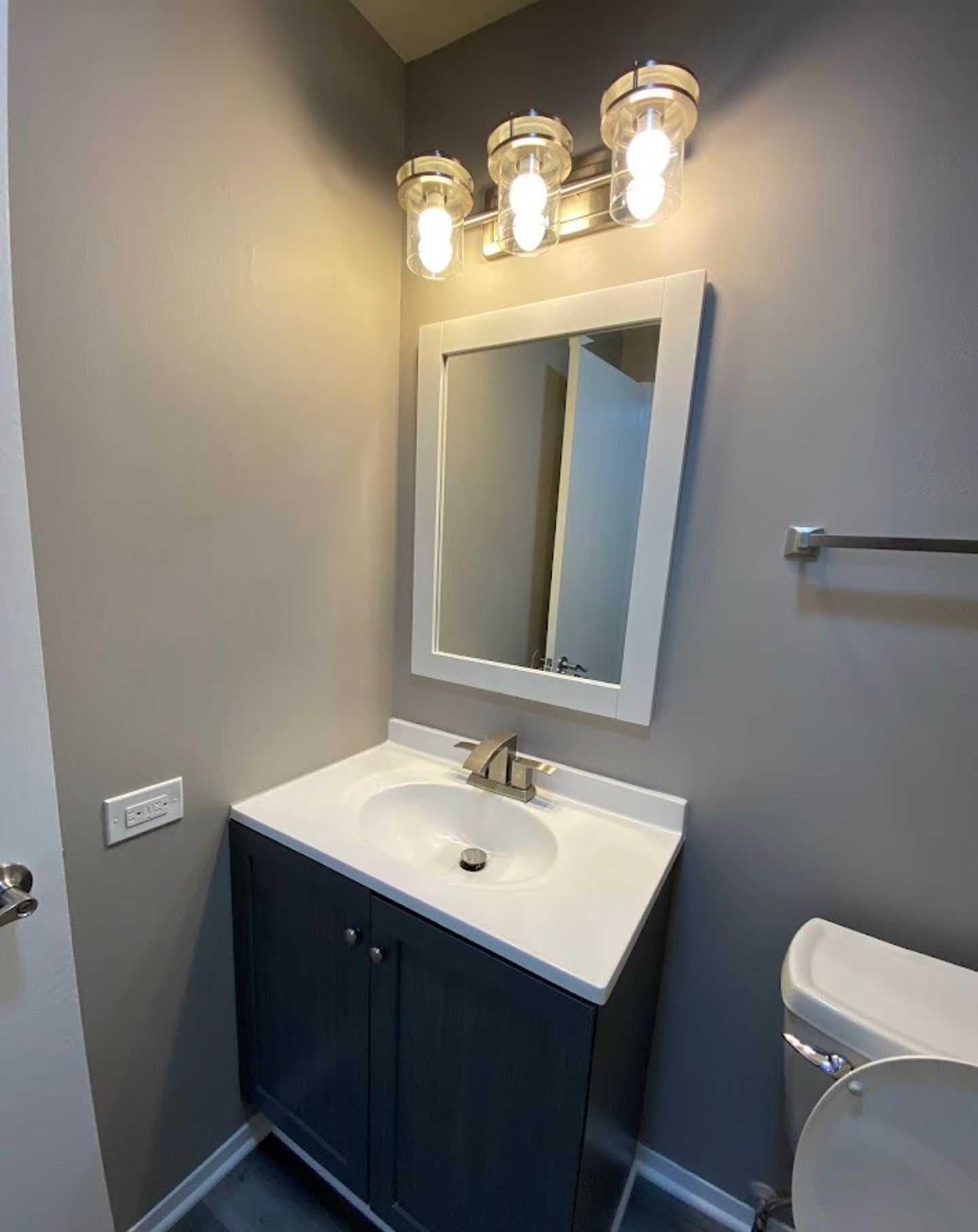 A bathroom with a sink , mirror and toilet.