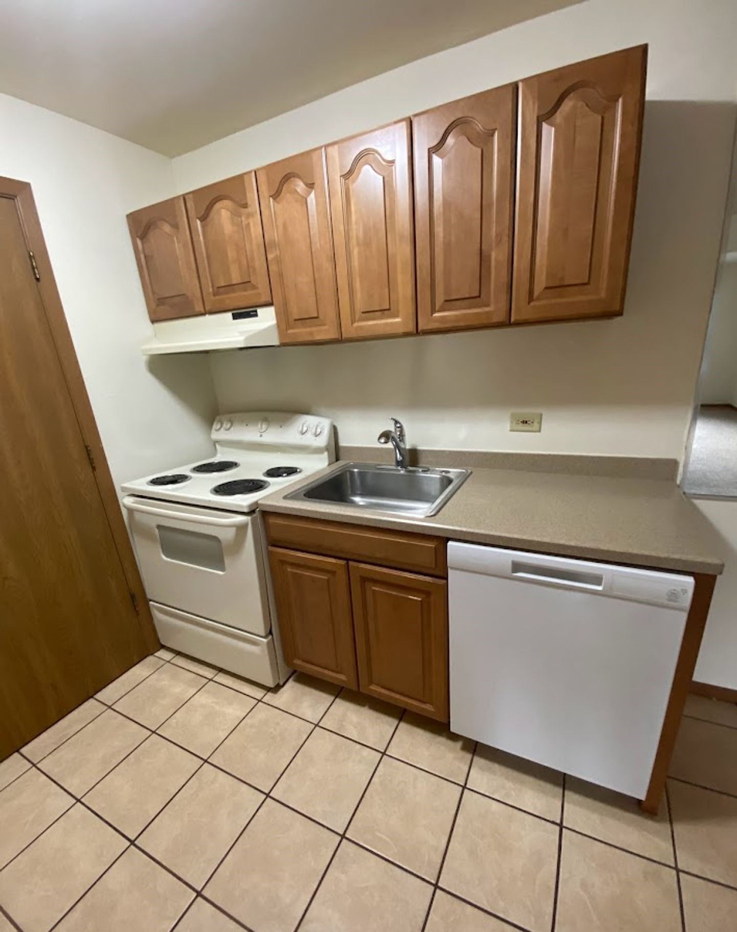 A kitchen with a stove , sink , and dishwasher.