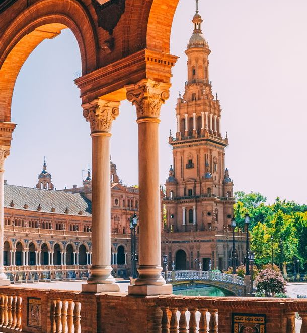 Professional private transfer in a premium vehicle navigating the historic boulevards of Seville, passing by the iconic Giralda tower and the city's grand cathedrals.