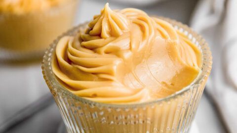 Postre de caramelo arremolinado en vaso transparente con dibujos.