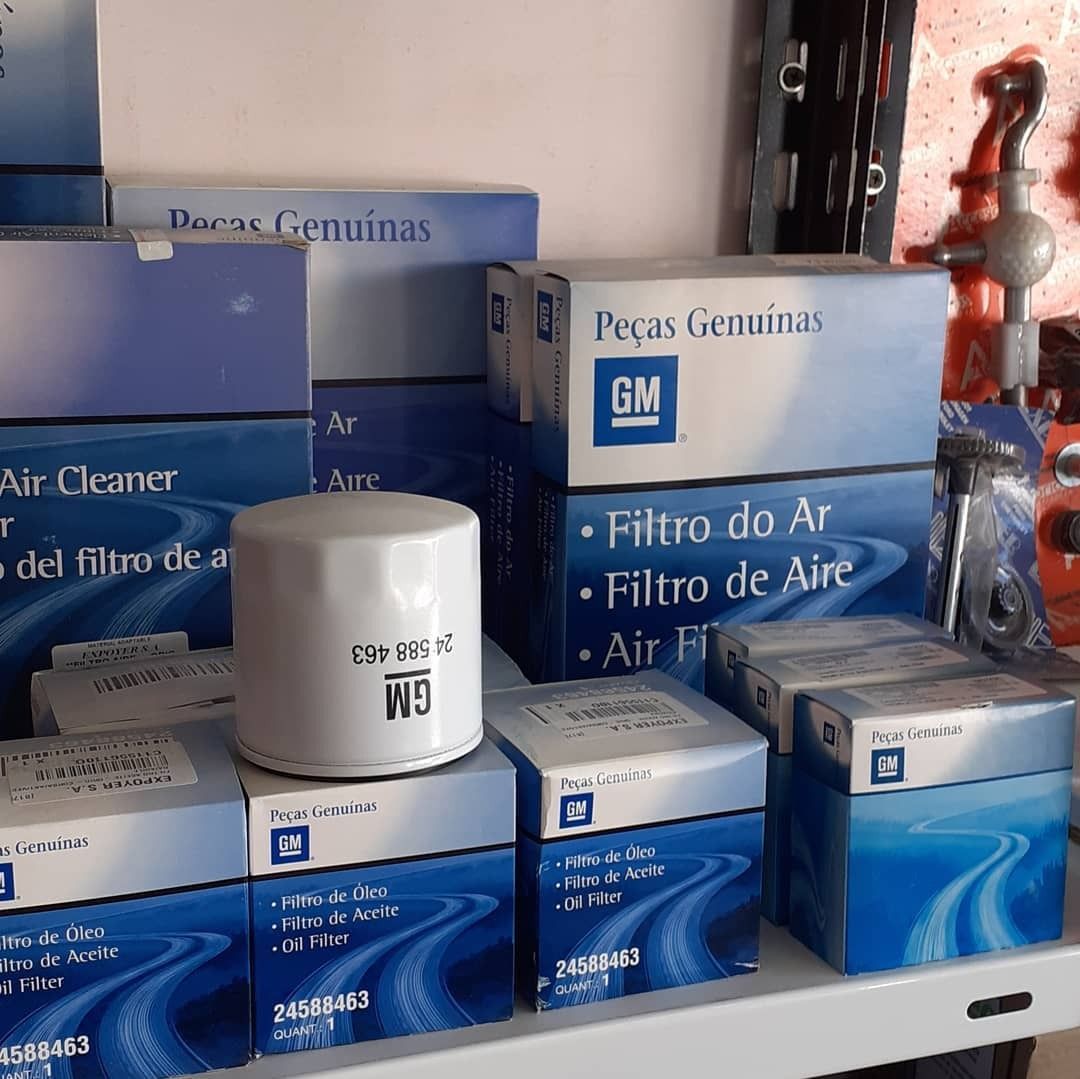 Cajas azules de repuestos de automóviles GM y filtros de aire apilados en un estante de una tienda