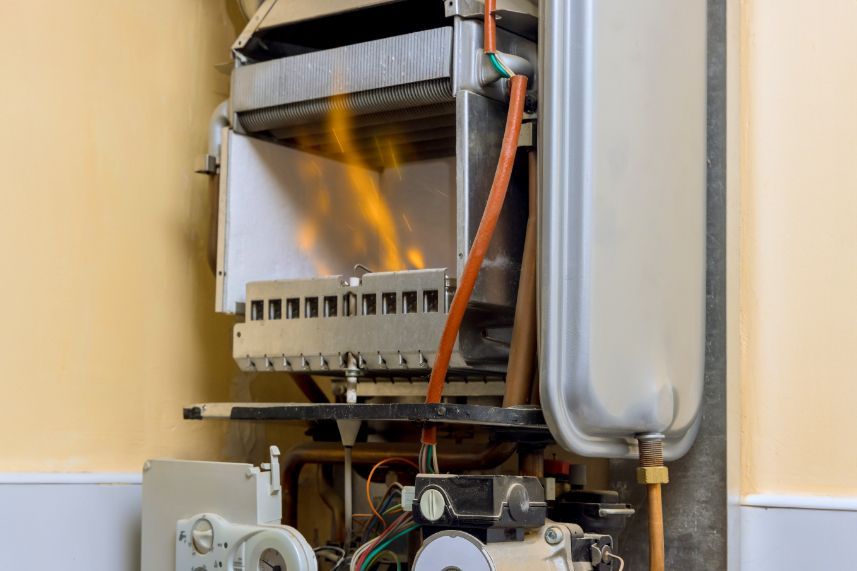 The inside of a gas boiler with flames coming out of it.