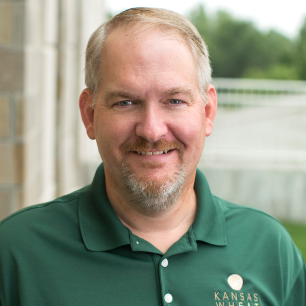 A man with a beard is wearing a green shirt that says kansas wheat