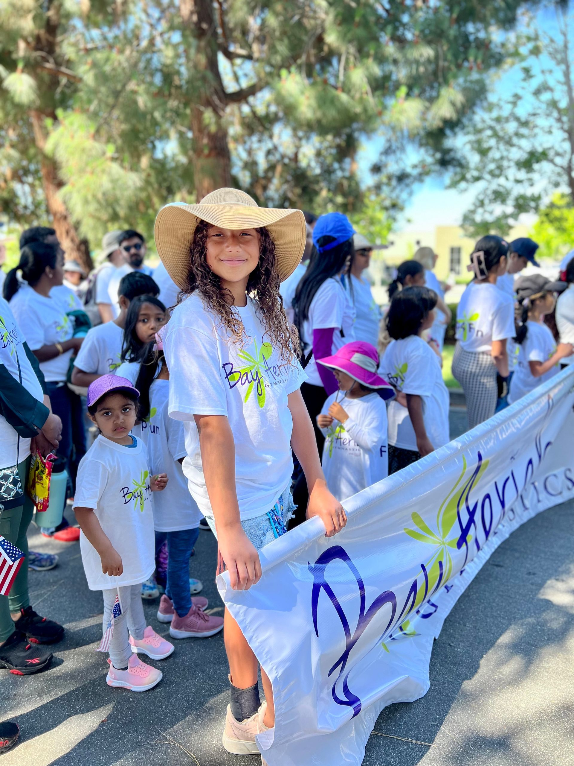 People in white t-shirts and hats holding a banner with a butterfly logo outside.