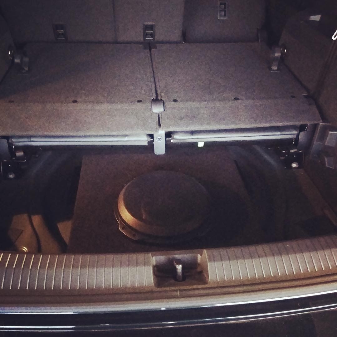 Open car trunk with a black subwoofer speaker box inside