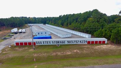 White storage building WITH RED DOORS AAA ETEX STORAGE SIGNAGE