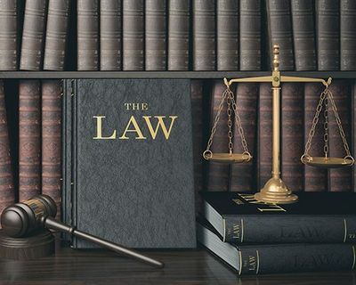 Law Bookshelf with Wooden Judge's Gavel and Golden Scale — South Hill, VA — Harris, Matthews & Crowder, P.C.