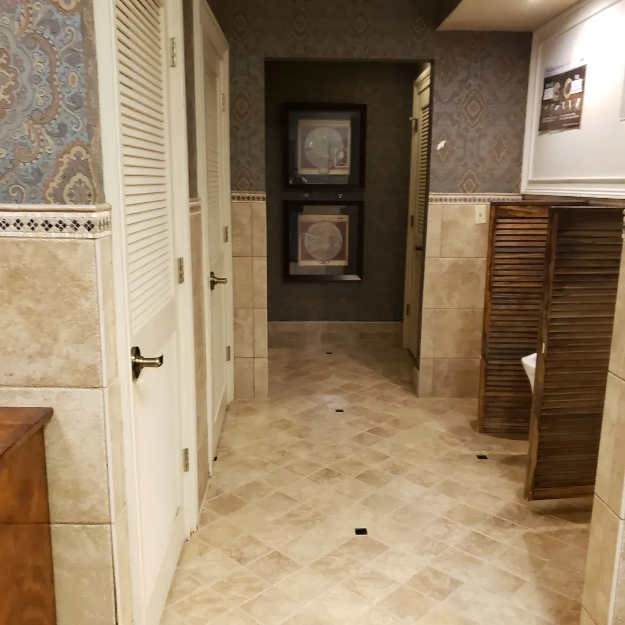 Hallway with three doors, patterned wallpaper, tile flooring, and decorative wooden screens.