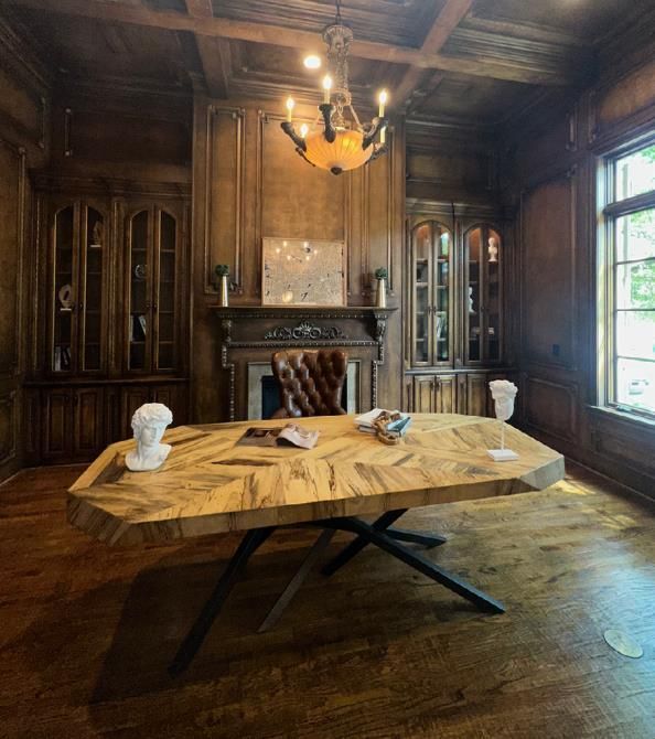 A wooden table in a room with a chandelier hanging from the ceiling