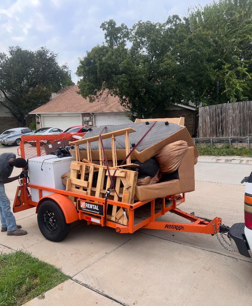 A man is standing in a kitchen working on a sink.