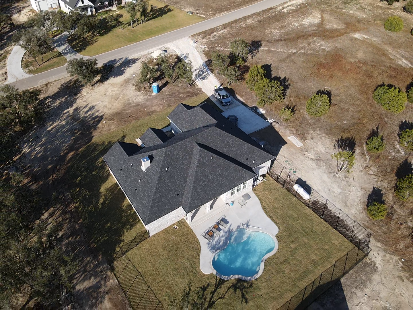 An aerial view of a house with a pool in the backyard