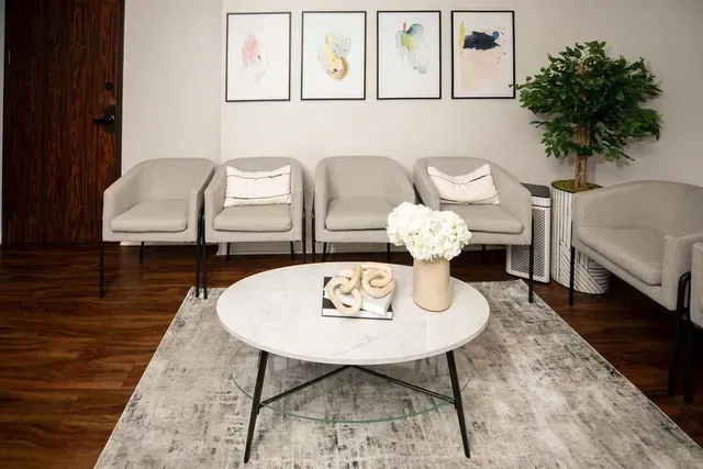 A waiting room with chairs and a coffee table.