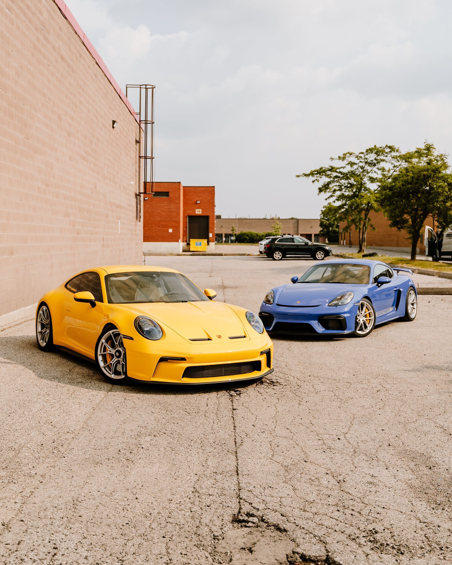 Two sports cars are parked next to each other in a parking lot.