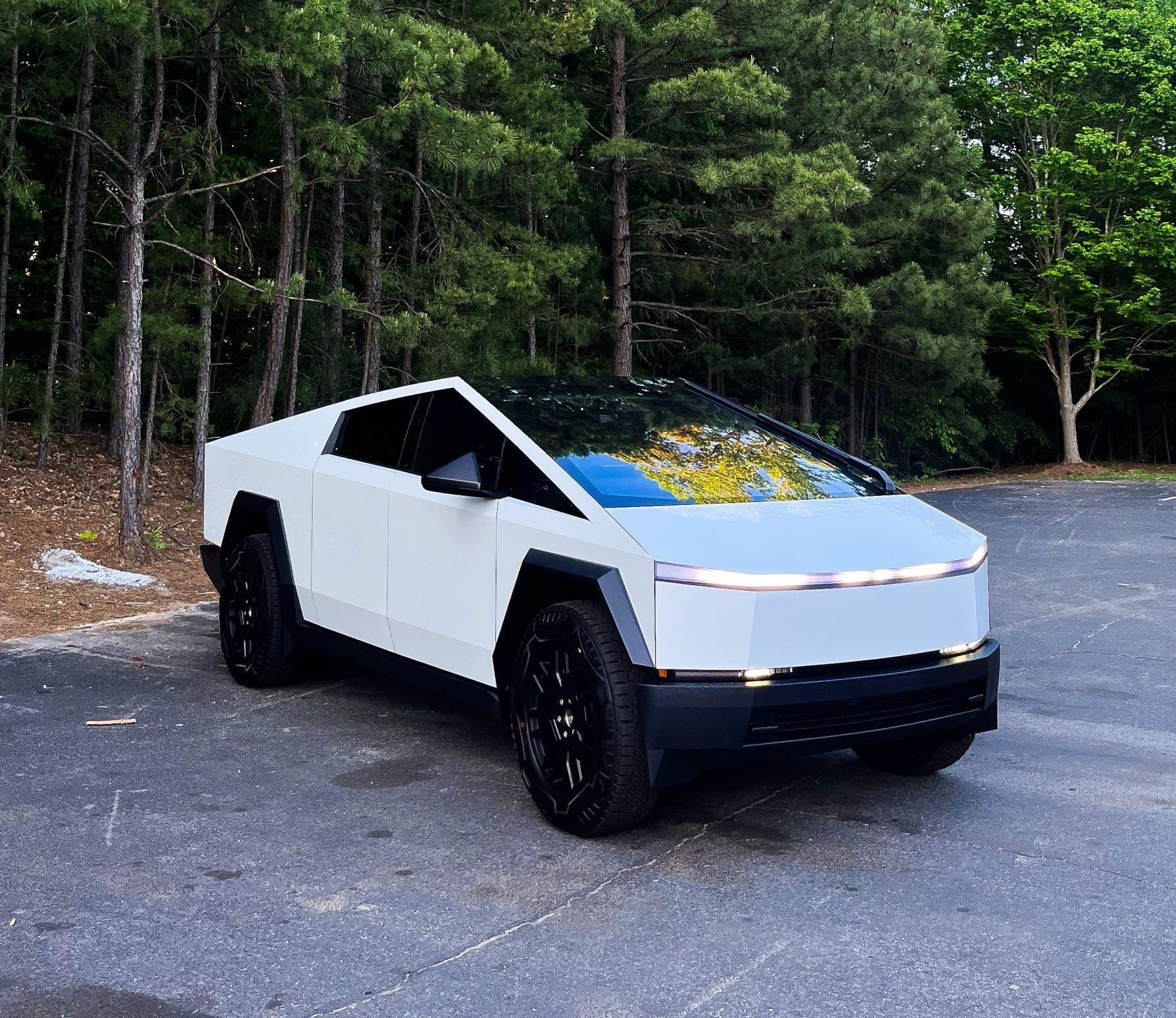 A white tesla cybertruck is parked in a parking lot