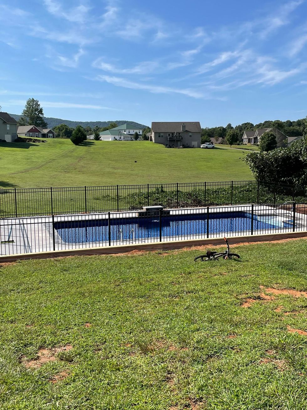 A large swimming pool is surrounded by a fence in a backyard in North Georgia