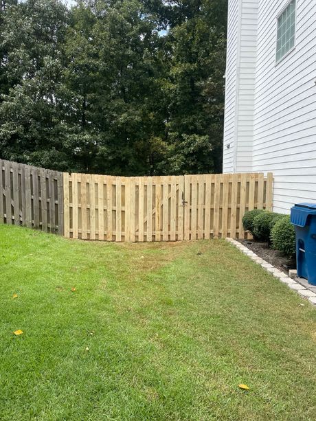 There is a wooden fence in the backyard of a house.