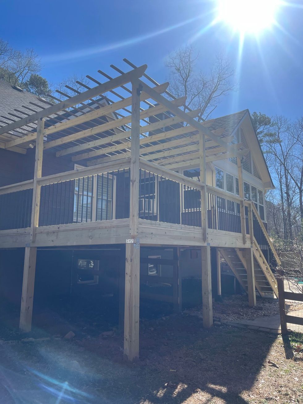A large wooden deck is being built on top of a house.