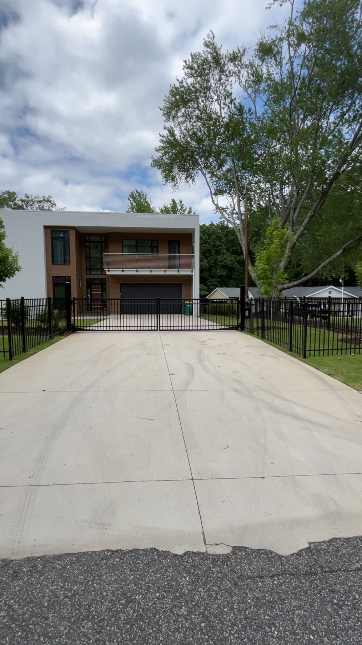 A large house with a meta gated driveway leading to it.