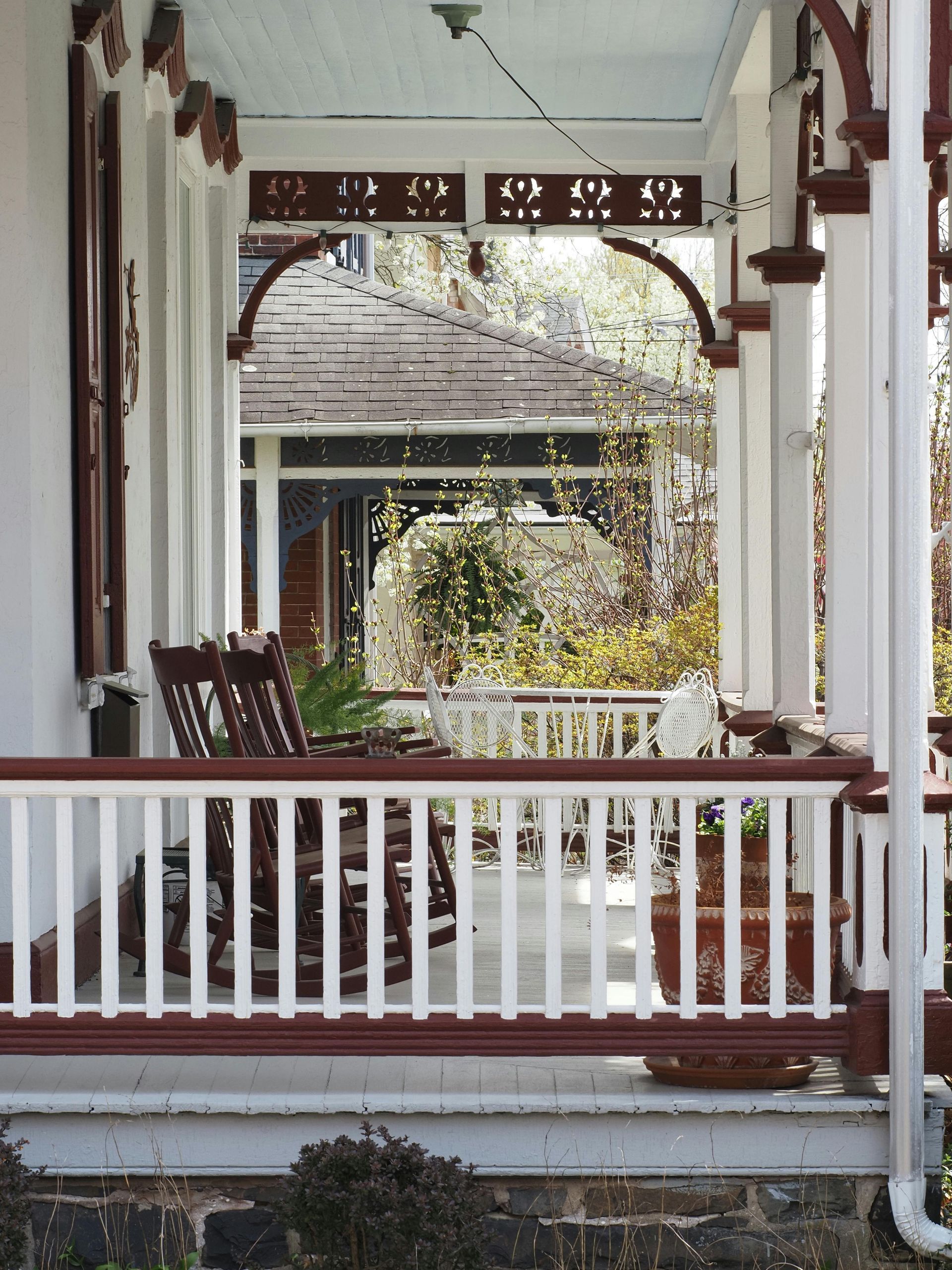 A porch with a white railing and rocking chairs