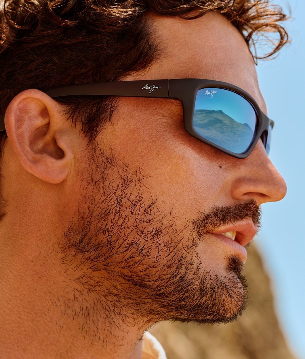 Man wearing Maui Jim Sunglasses with blue sky background