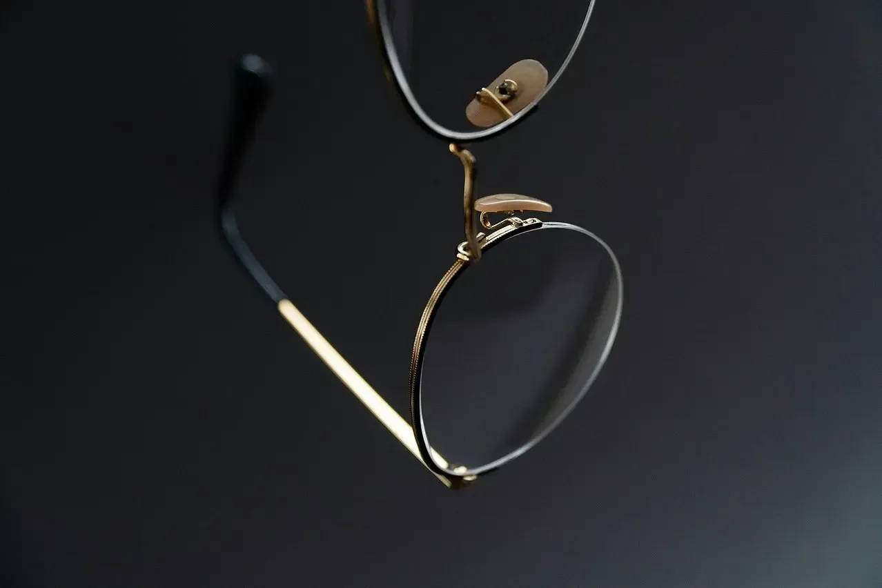 A pair of glasses laying on a black surface